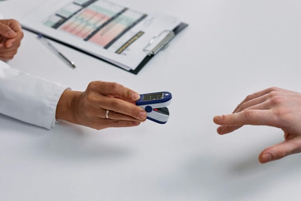 Close-up of Doctor Putting a Fingertip Pulse Oximeter on a Patients Finger