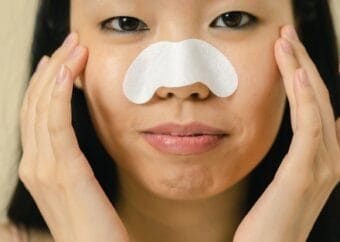 A woman using a nose strip for skincare routine