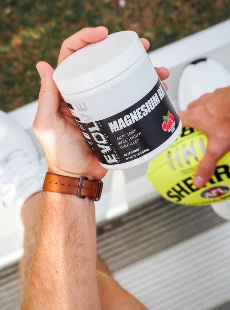 a man holding a jar of The best magnesium supplement